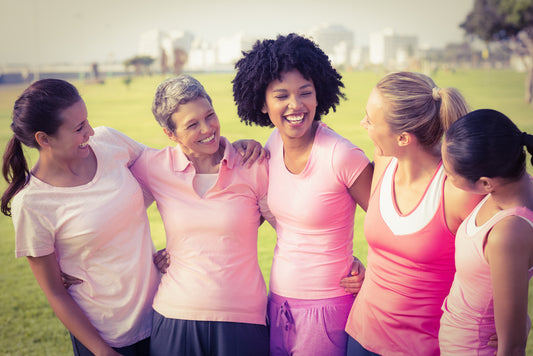 Five smiling women in workout clothes on athletic field