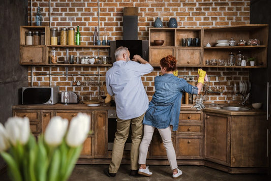 a couple dancing in the kitchen to music while making dinner