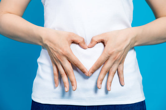 a person holding their hands in the shape of a heart on their belly