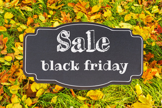 black Friday sale sign displayed against a background of grass and fall colored leaves