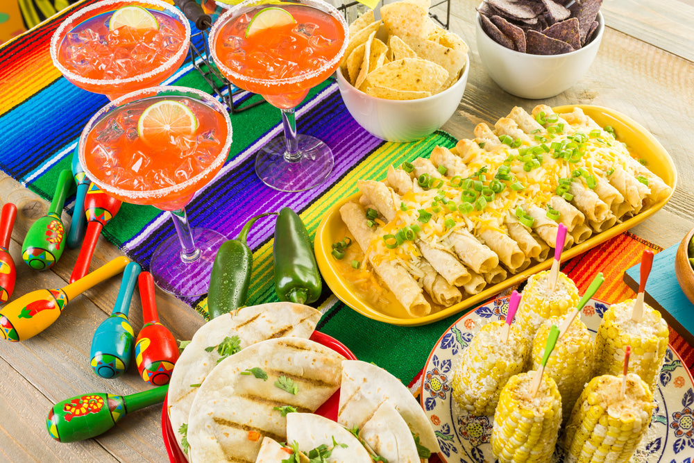 a platter of margaritas, tacos, enchiladas, and corn