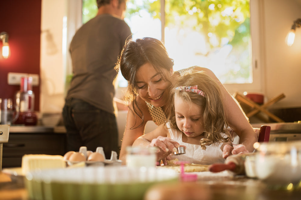 mother and young daughter making cookies