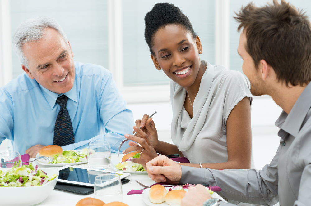 people at the office eating lunch at a table together
