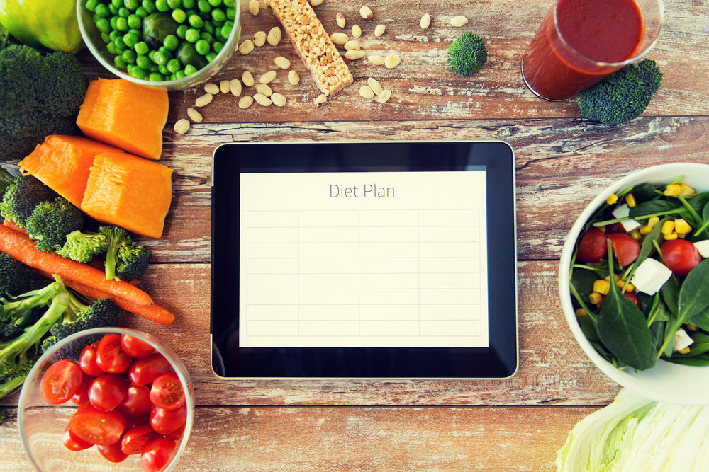 vegetables displayed on a table around a tablet with a check list app open