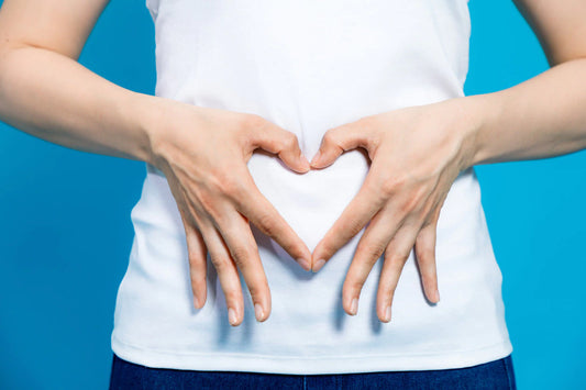 a woman with her hands in the shape of a heart against her belly